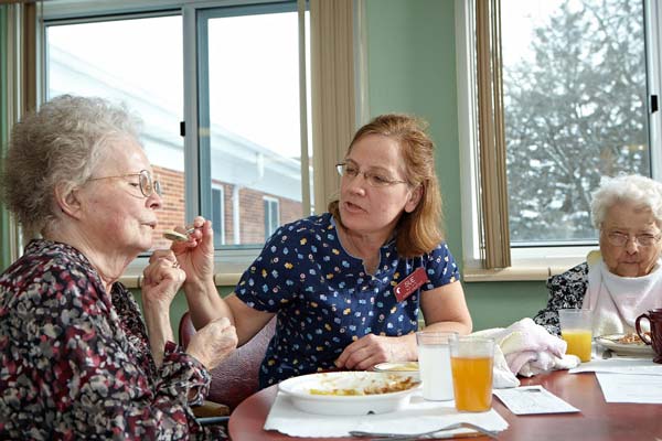 Nurse assisting resident with meal